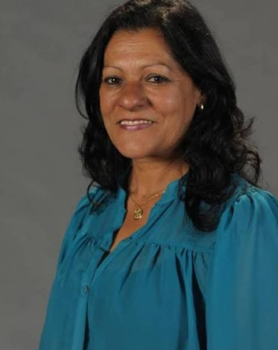 Foto de Luci Alves de lado e com blusa de botão azul