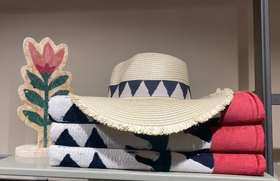 Foto de chapéu de palha e toalhas da nova coleção da Riachuelo