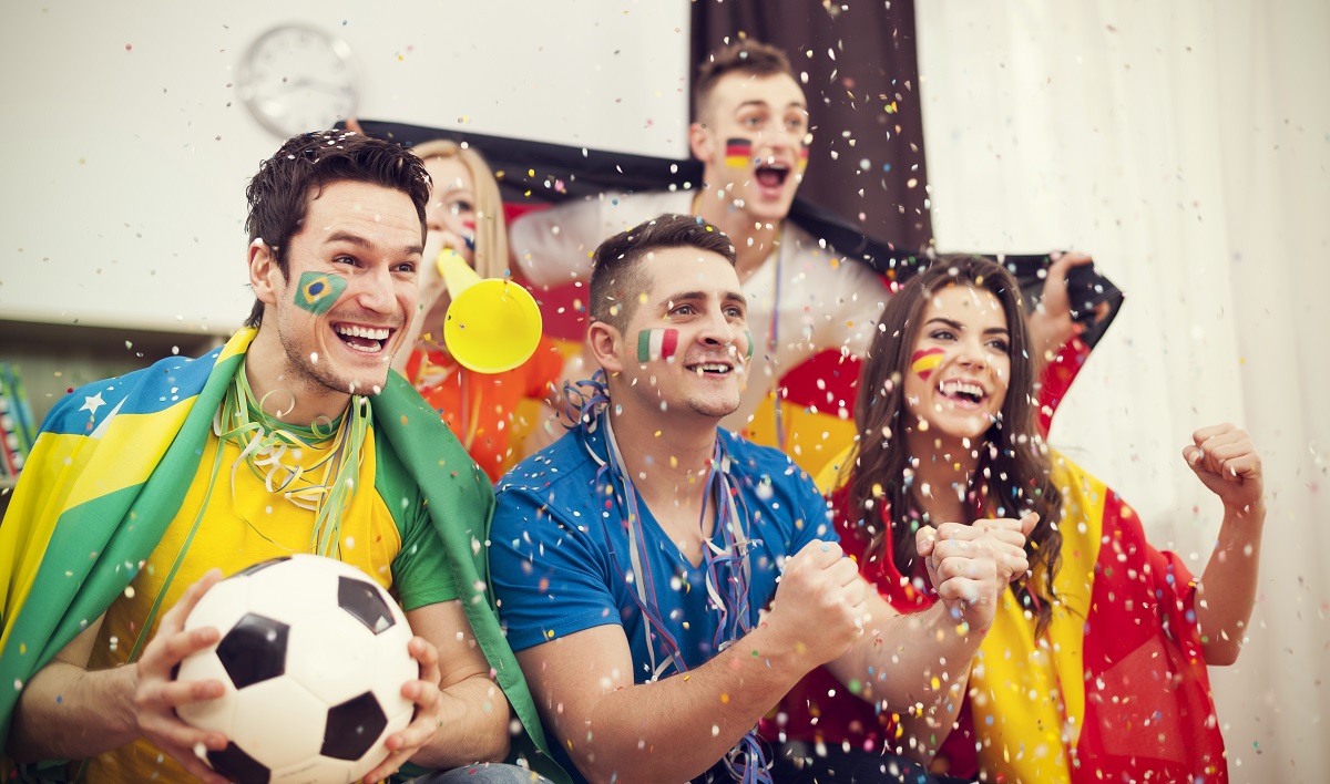pessoas torcendo para seleções de futebol com bandeiras do Brasil, Itália, Espanha e Alemanha desenhadas no rosto 