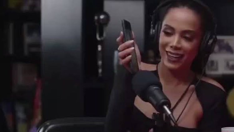 Anitta aponta celular para o microfone e exibe áudio de Lula em entrevista.