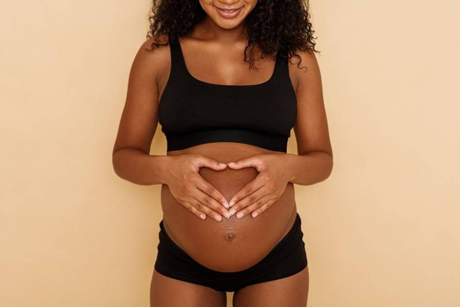 Dentre os benefícios do vinho está o aumento da chance de engravidar. Imagem com mulher grávida.