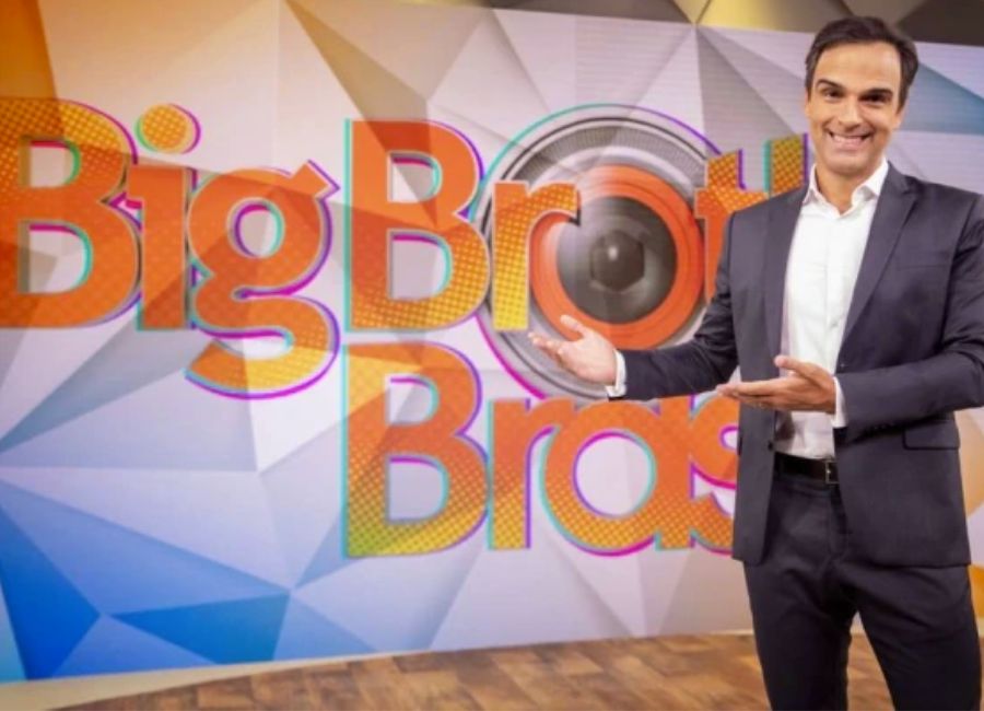 O apresentador Tadeu Schmidt na frente do letreiro do Big Brother Brasil