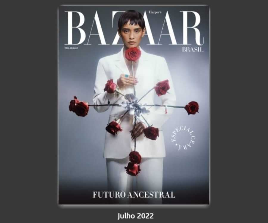 Print do aplicativo Harper's Bazaar com foto da capa da edição julho 2022. Nela está a atriz Taís Araújo segurando uma obra de arte com várias rosas vermelhas.