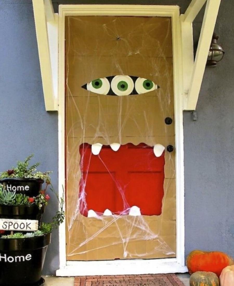 Porta de Halloween decorada com olhos e boca de monstro.