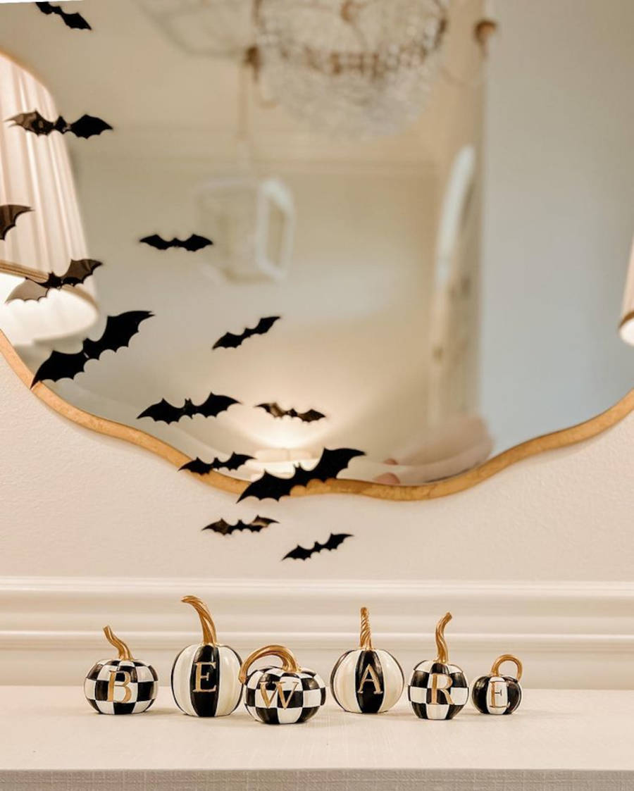 Desenhos de morcego e objetos de abóboras em preto e branco.