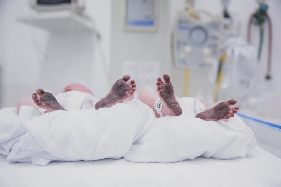 Foto dos pezinhos de Mel e Bento carimbados (Teste do Pezinho), gêmeos de Isabella Scherer. Eles estão deitados em toalhas, na maternidade.