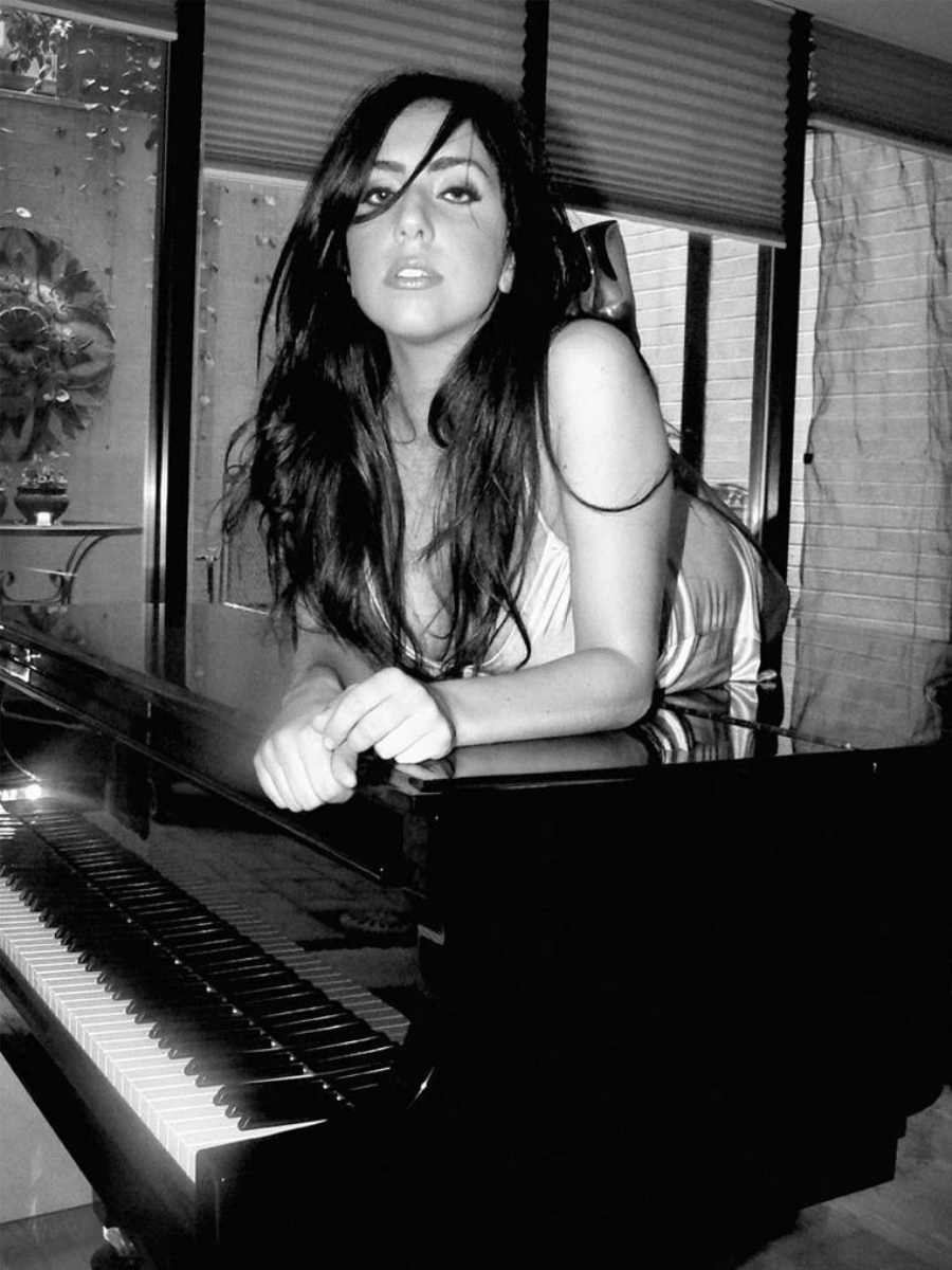 Stefani Germanotta deitada sobre piano fazendo carão antes da fama.
