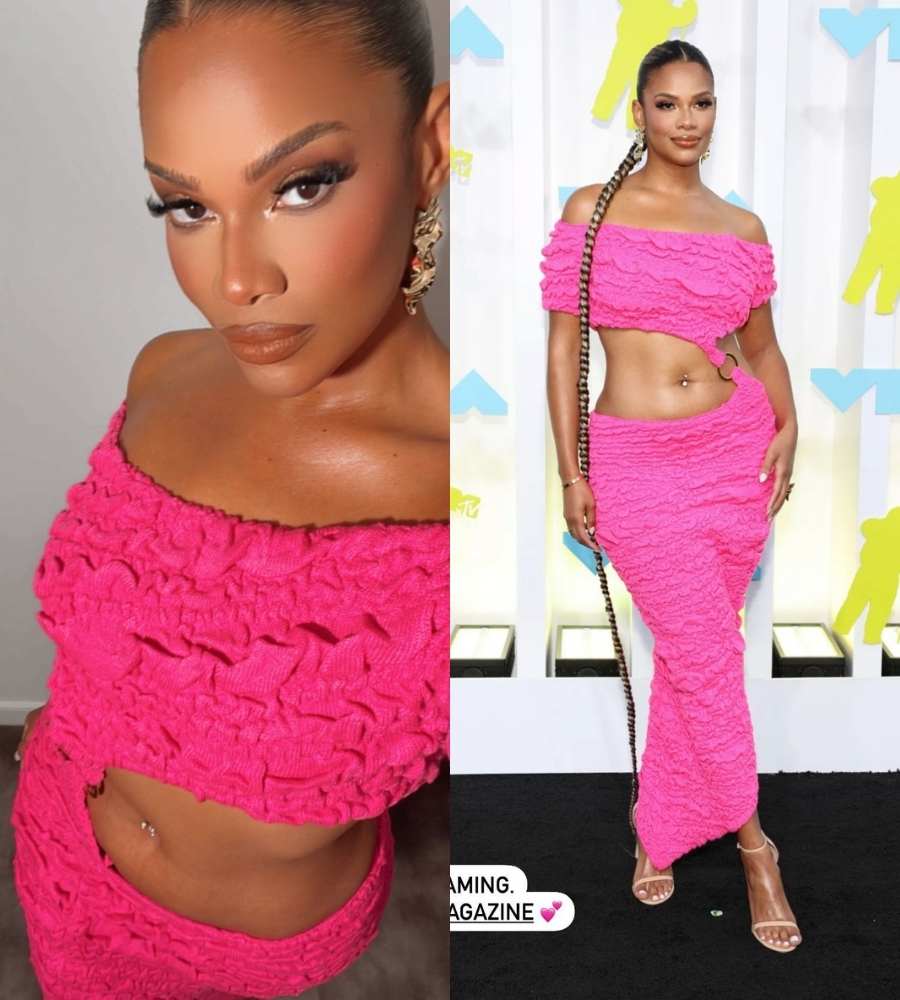 Duas fotos de Kamie Crawford. A 1ª é uma selfie dela, mostrando a meke e seu look pink. Na 2ª foto, ela está no tapete do evento, de perna cruzada, usando vestido pink e longa trança até os pés.