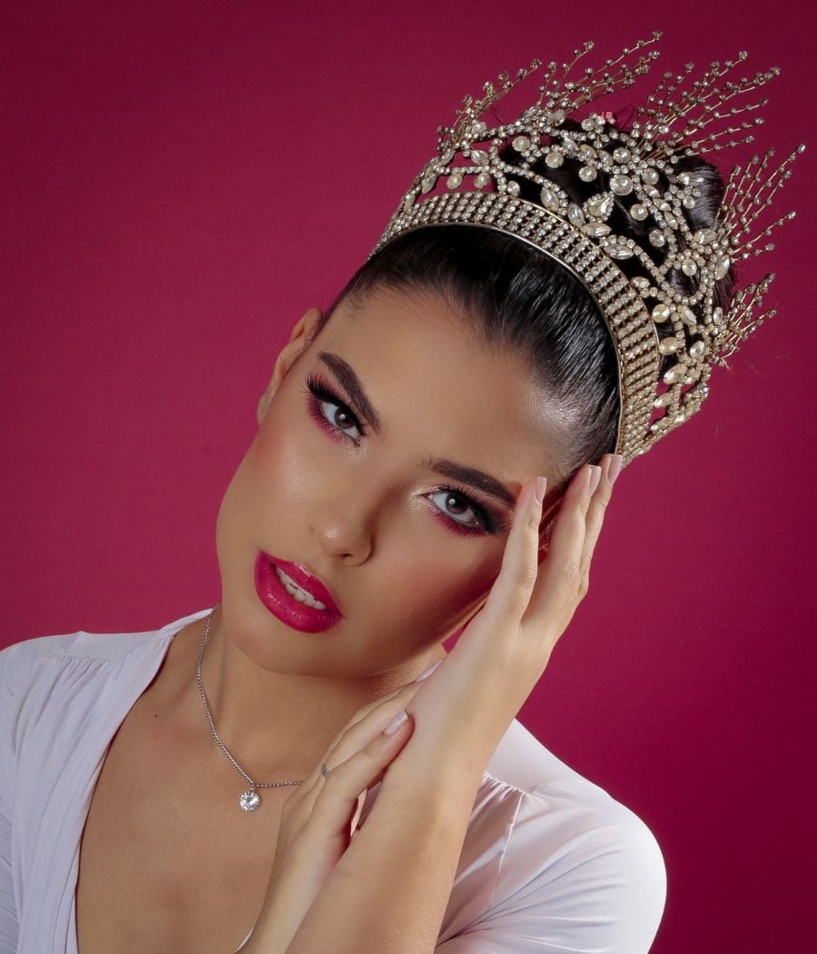 A Miss Goiás posa em um fundo vermelho usando uma coroa