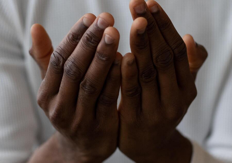 mãos de um homem negro em formato de prece