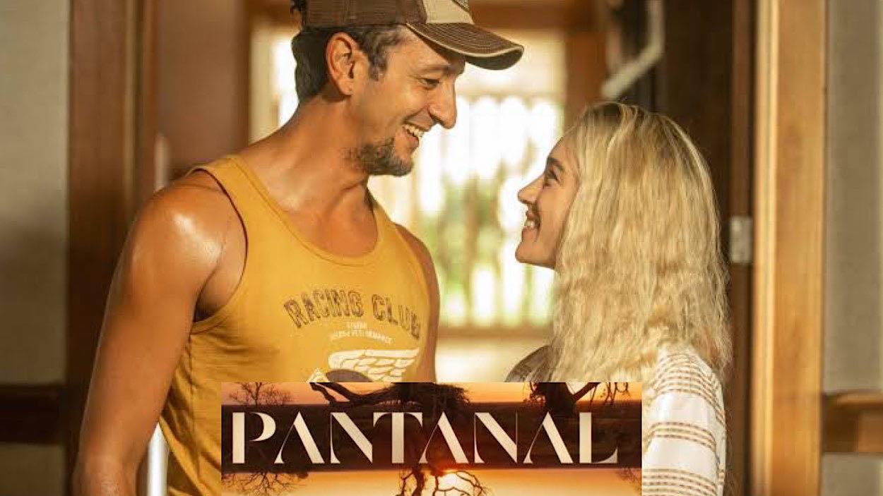 José Lucas e Érica trocam olhares e riem no cenário da novela Pantanal
