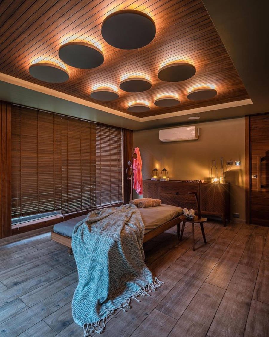 Quarto de massagem grande iluminado com spots de LED e velas.