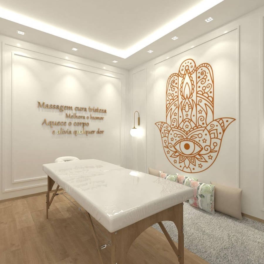 Quarto de massagem branco com mensagem positiva e arte na parede.