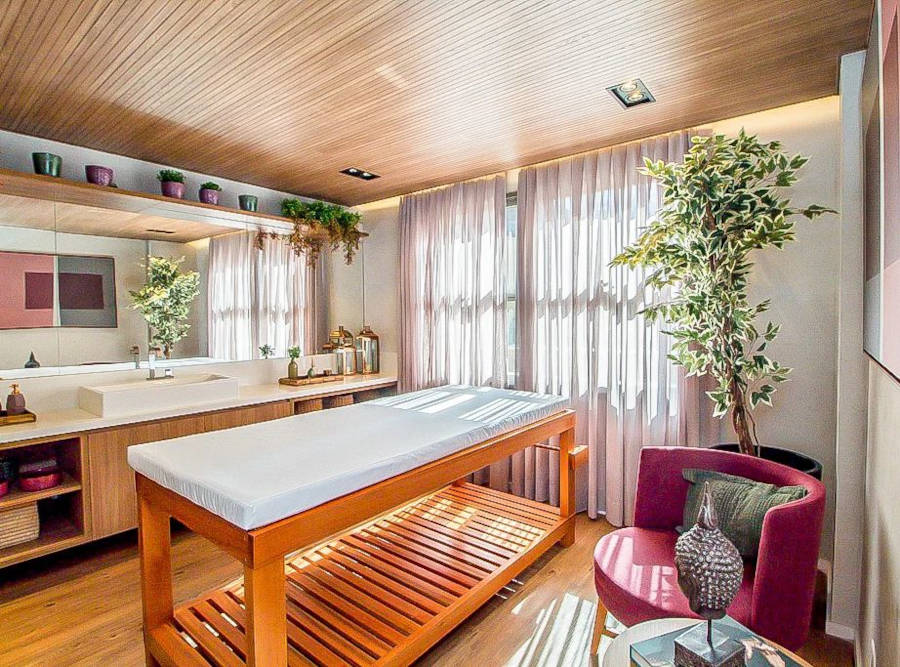 Quarto de massagem com pia na bancada e maca centralizada.