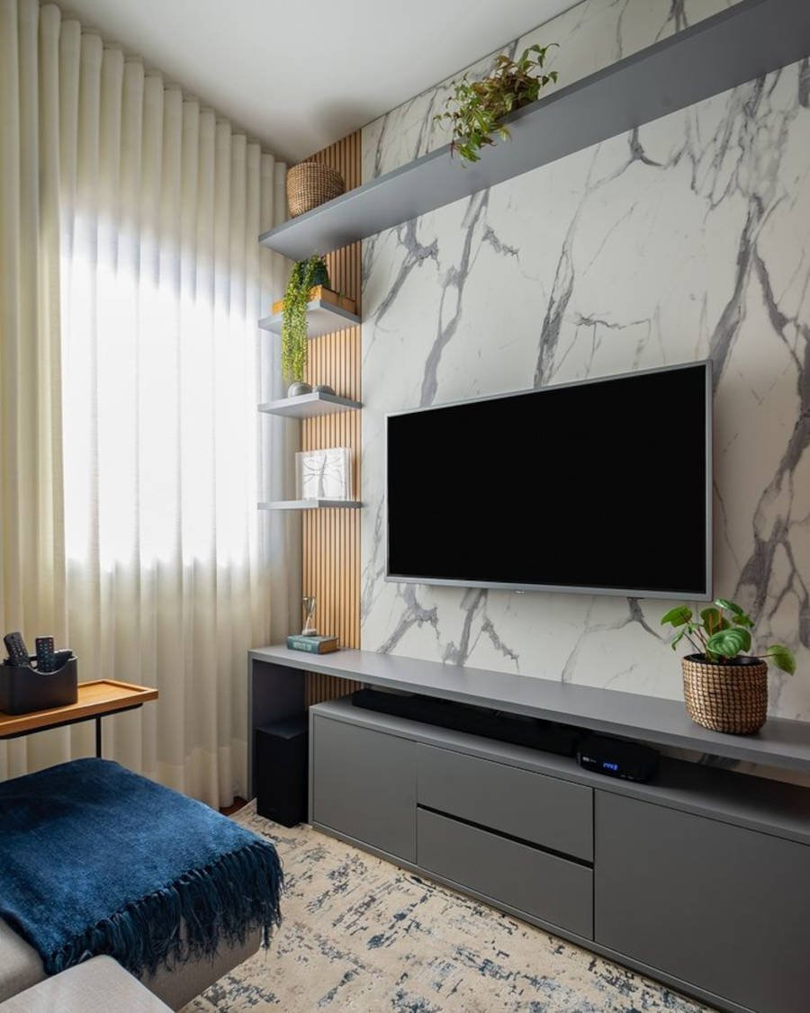 Sala de tv pequena com parede de mármore.