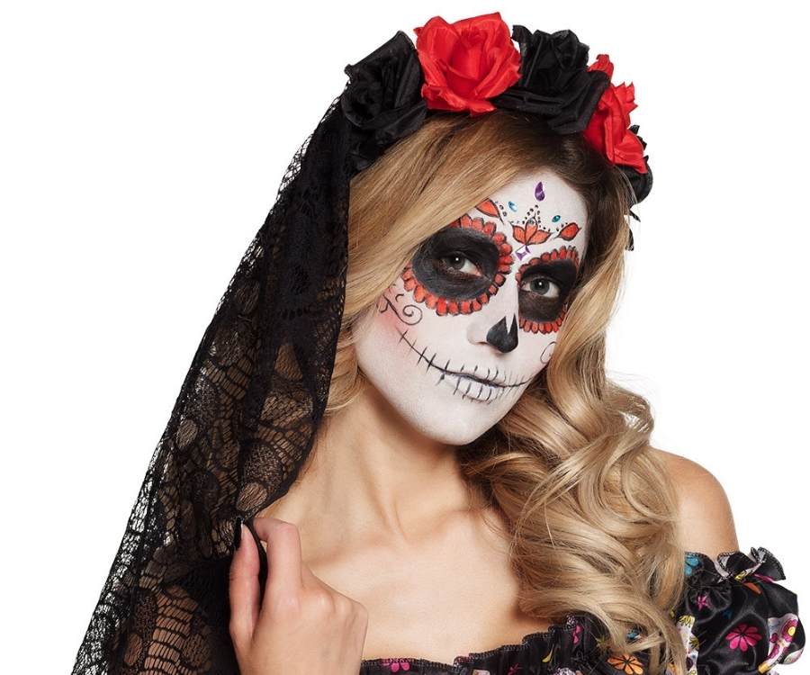 Modelo fantasiada de caveira mexicana para o Halloween. Está maquiada e com tiara de rosas e véu de renda preta na cabeça.