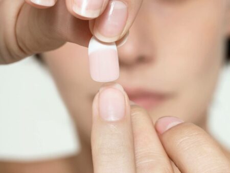 Mulher colocando unhas atificiais.