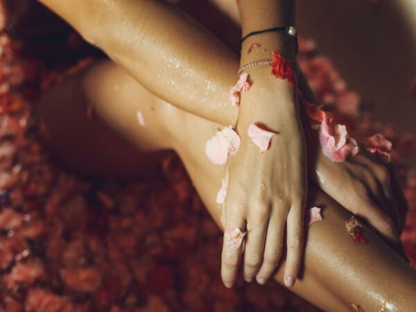 mulher tomando banho de rosas em uma banheira