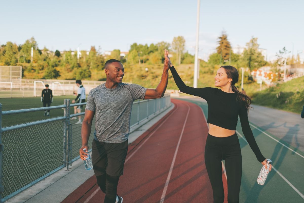 foto de homem e mulher usando roupas fitness e dando as mãos, por que evitar o sedentarismo
