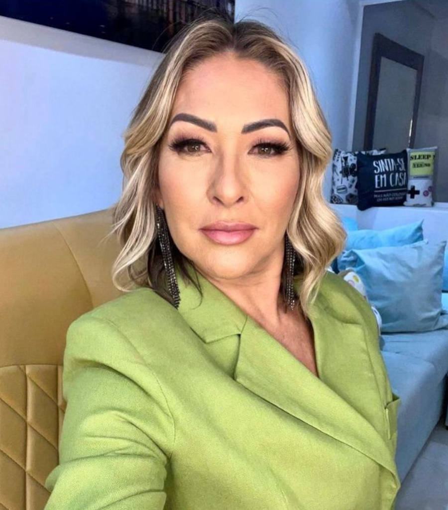 Foto selfie de Claudia Baronesa em um sofá usando blazer verde neon
