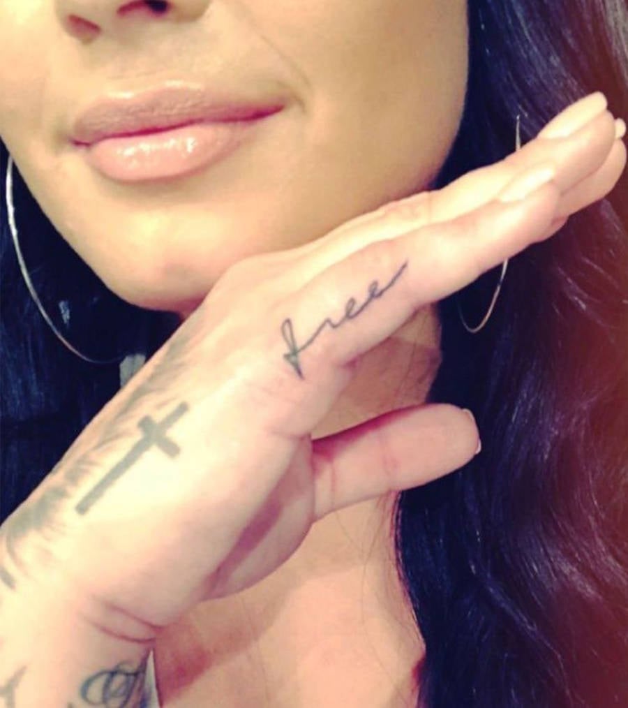 No dedo mindinho, Demi tem uma tatuagem escrito "free"