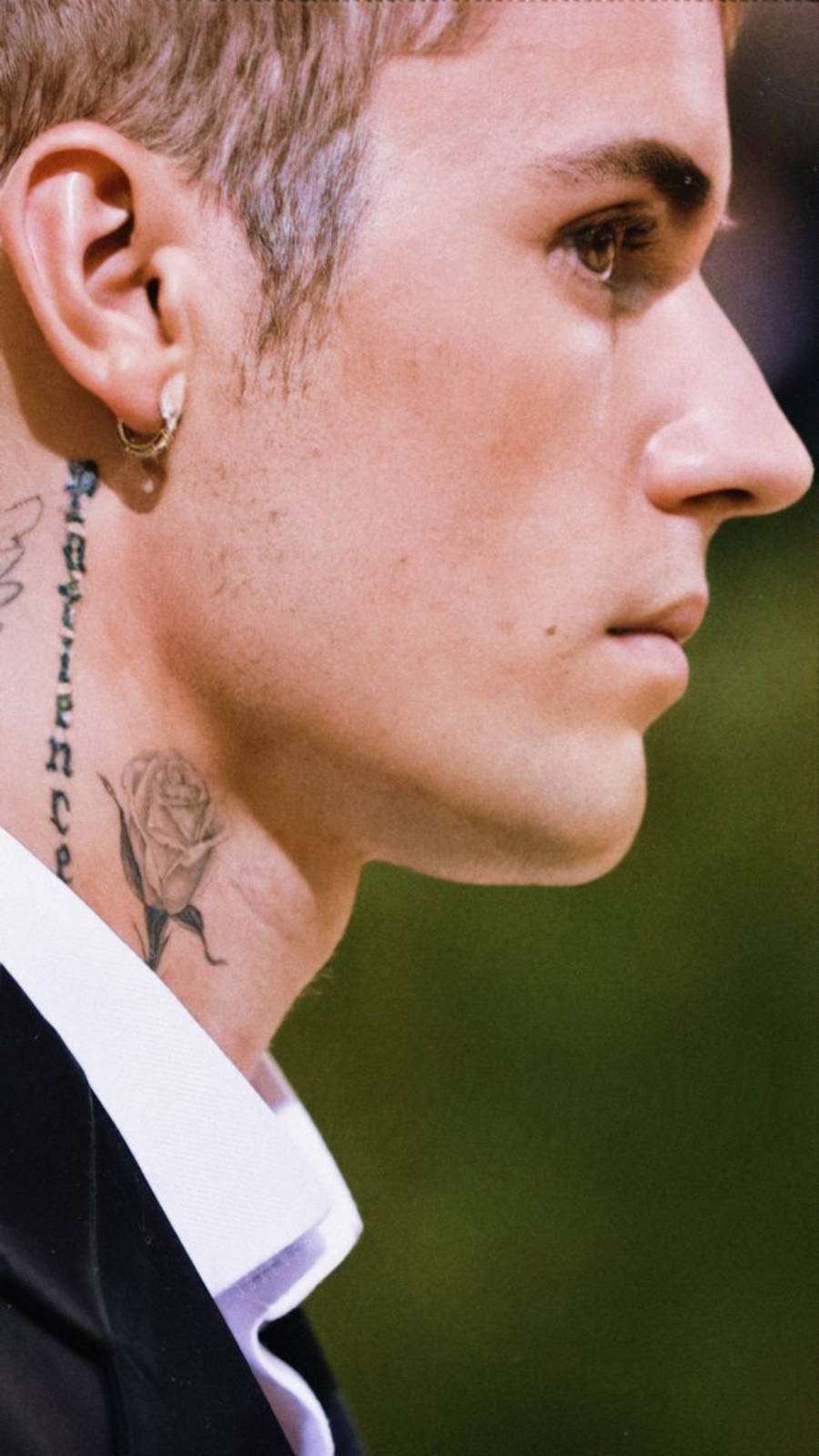 Foto de Justin Bieber de lado com foco em sua tatuagem "Patience"