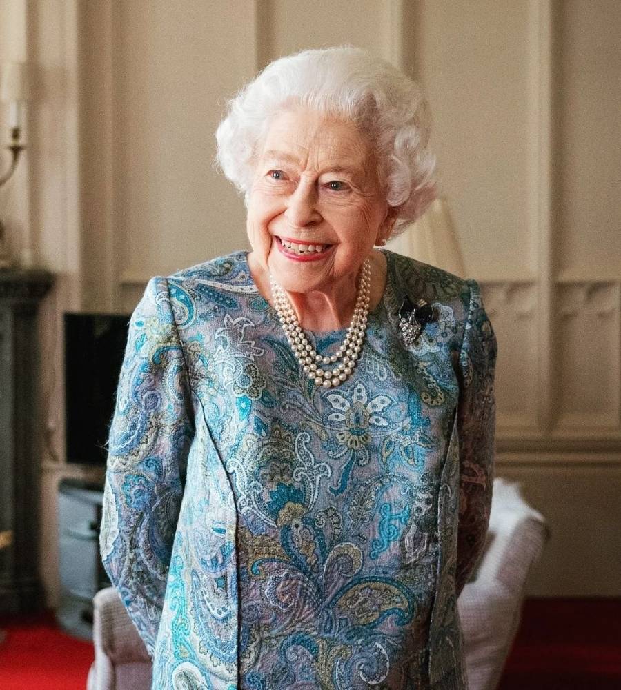 rainha Elizabeth II usando vestido azul com estampa floral e colar de pérolas em 2022
