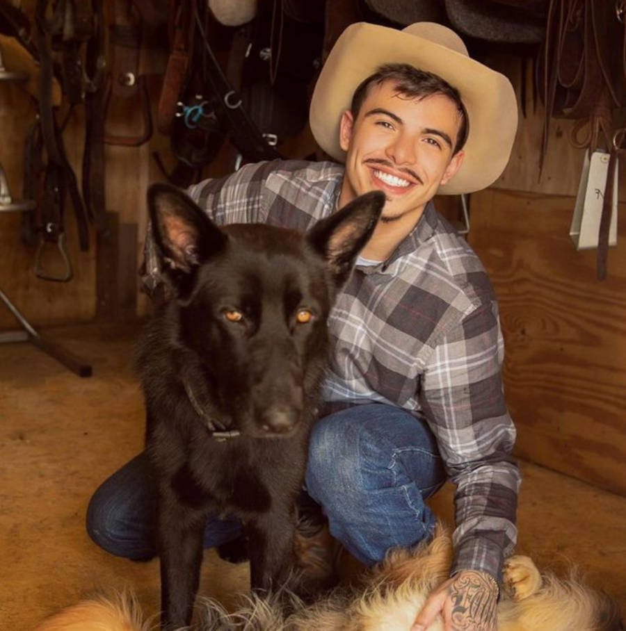Foto de Thomaz Costa em uma Fazenda com um cachorro