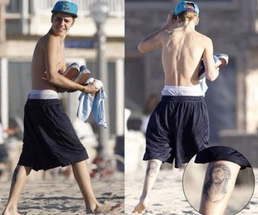 Foto de Justin Bieber mais novo na praia, com destaque na sua tatuagem de Jesus Cristo