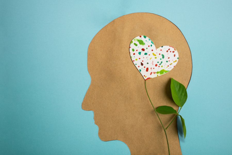 silhueta de pessoa feita de papel com desenho de coração colorido na cabeça