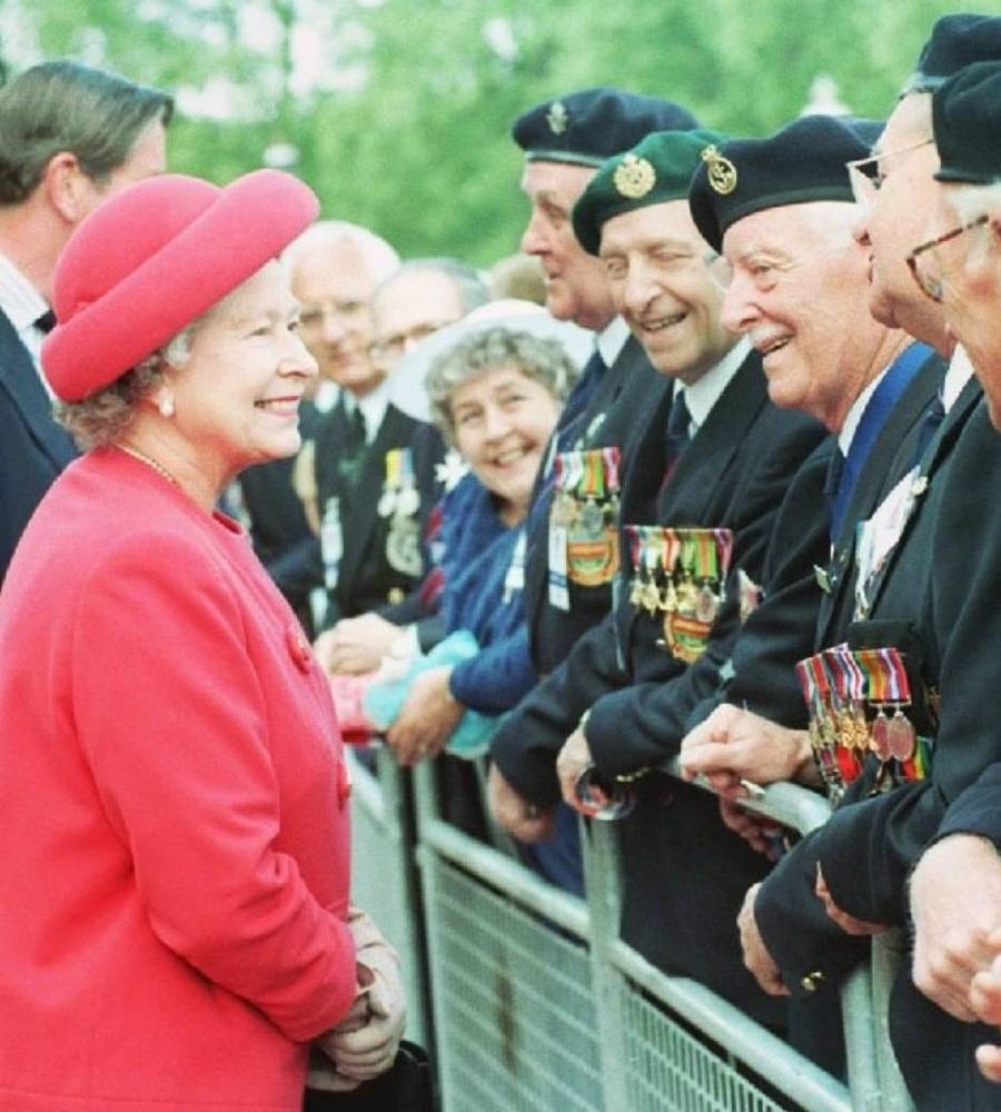 monarca do Reino Unido em 1995 usando terno vermelho e chapéu da mesma cor