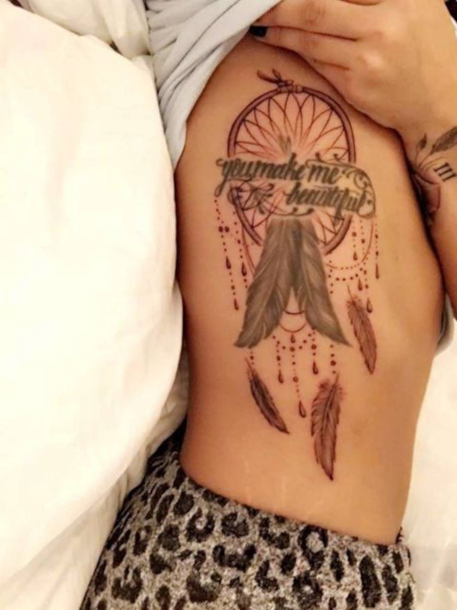 Foto da lateral da costela de Demi Lovato com a tatuagem "You make me beautiful"