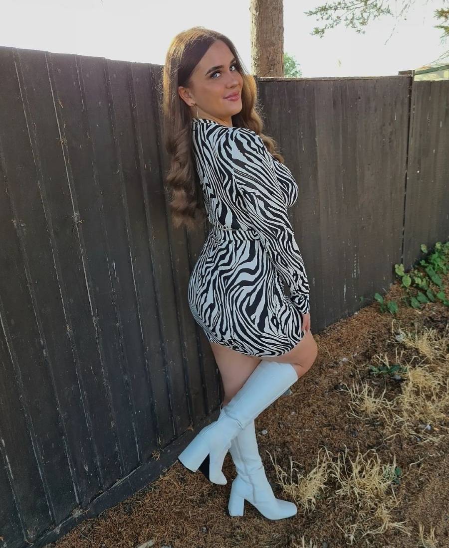 mulher usando conjunto de zebra cropped e saia com bota branca