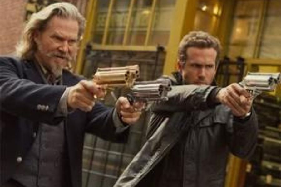 Atores Jeff Bridges (Roycephus) e Ryan Reynolds (Nick Walker) de R.I.P.D - Agentes do Além. Eles estão em cena, armados e apontando as masmas na mesma direção.