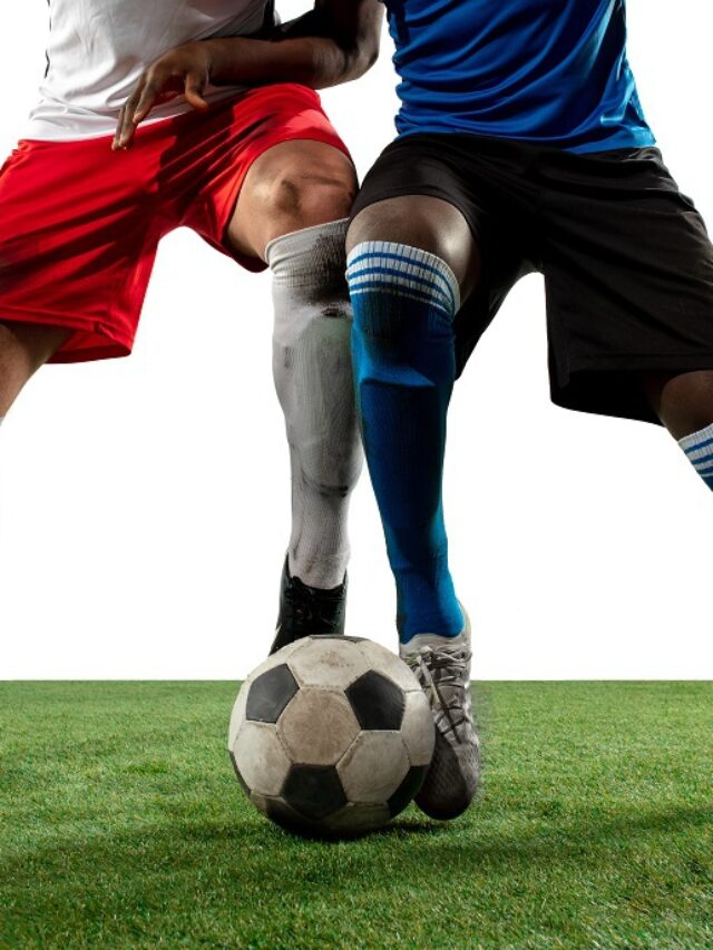 Close up legs of professional soccer, football players fighting for ball on field isolated on white background