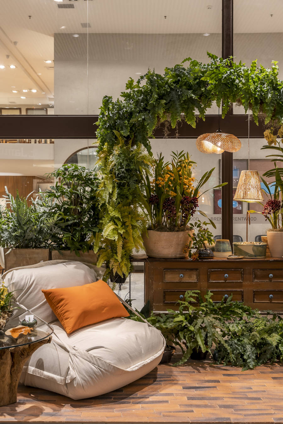 Puxe brando com cômoda de madeira e arco de plantas.