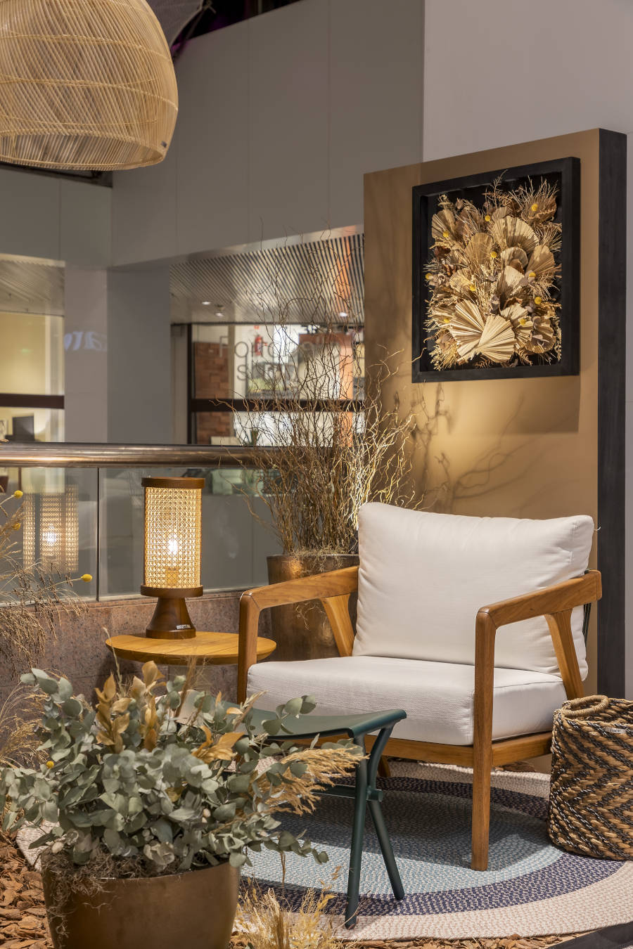 Ambiente interno com mesa de cabeceira, poltrona e tapete.