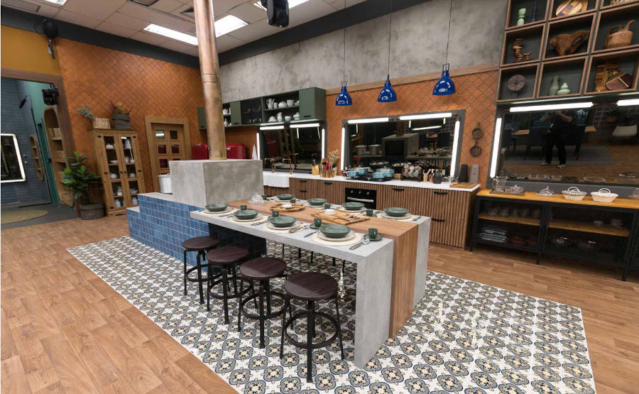Cozinha com fogão de lenha e mesa emendada na decoração de A Fazenda 2022.