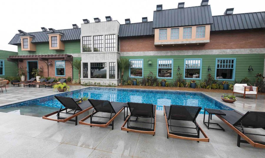 Espreguiçadeiras ao lado da piscina.