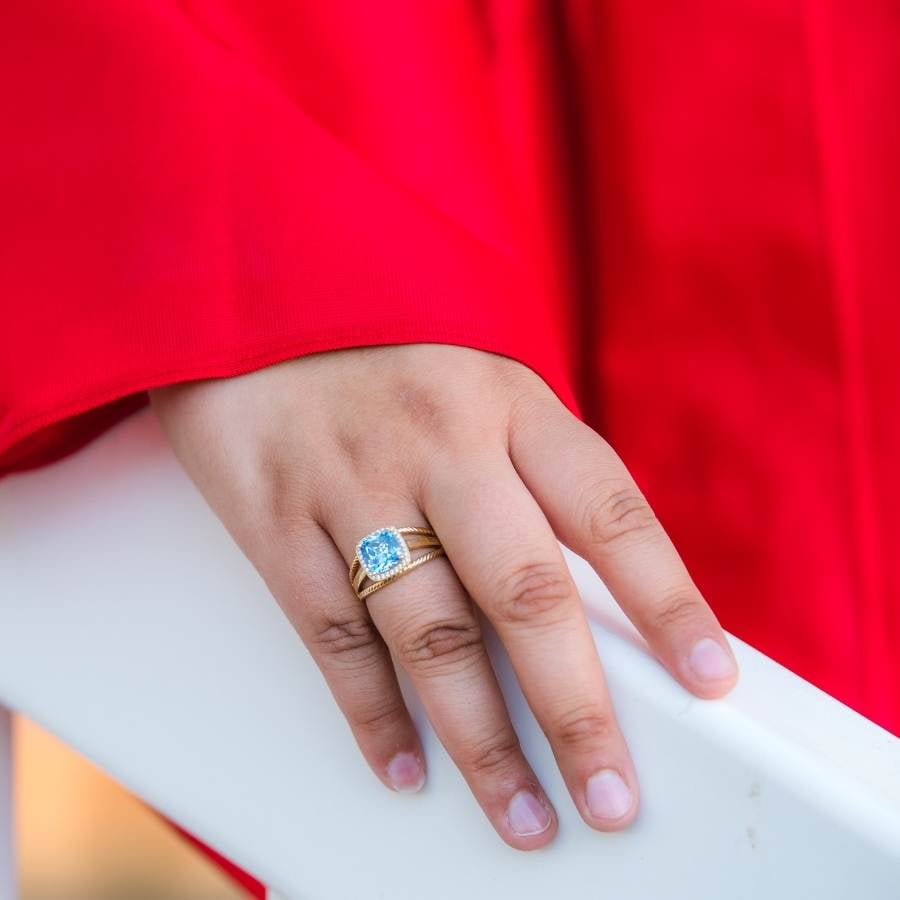Foto de mão com anel pedra azul no dedo anelar.