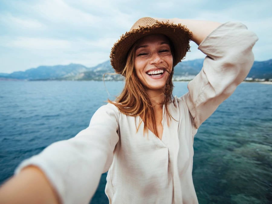 Foto de mulher tirando selfie em frente ao mar