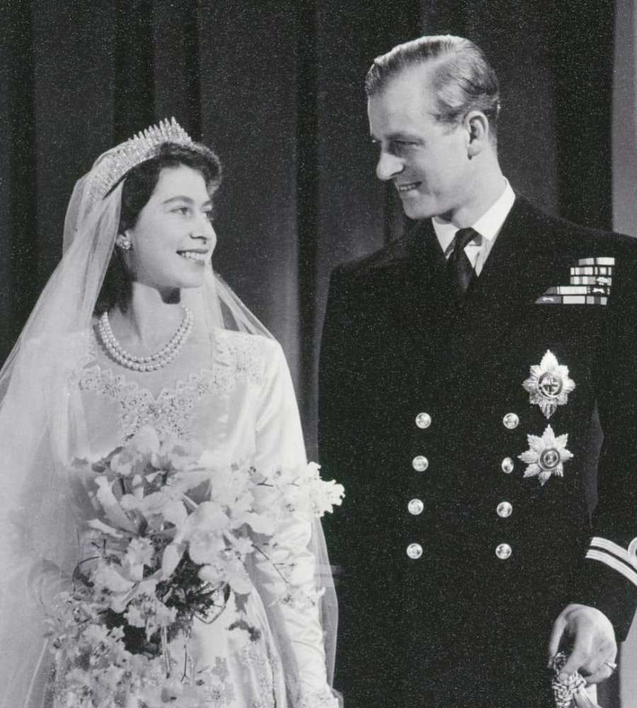 Foto da Rainha Elizabeth II e do Prínciple Phillip no dia de seu casamento. Estão vestidos de noivos.