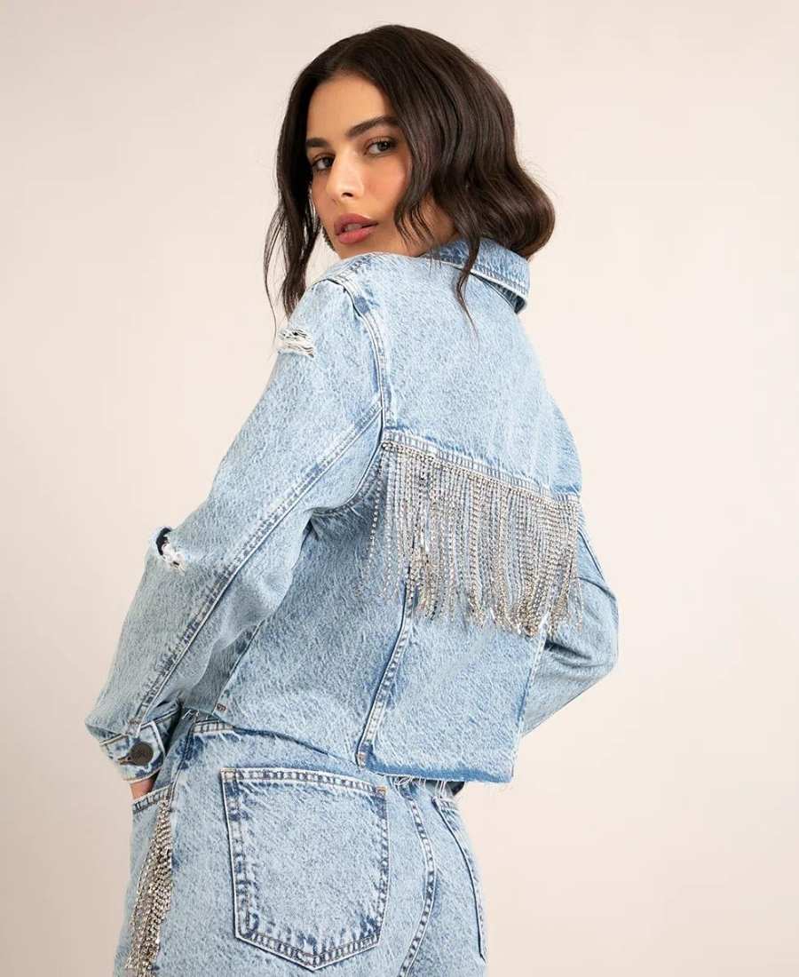 Foto de modelo usando jaqueta jeans com fitas de strass.
