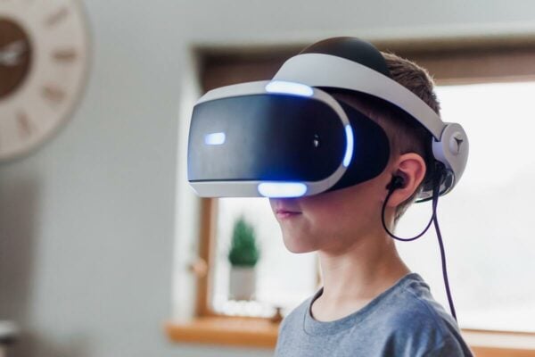 criança com fone de ouvido usando óculo de realidade virtual