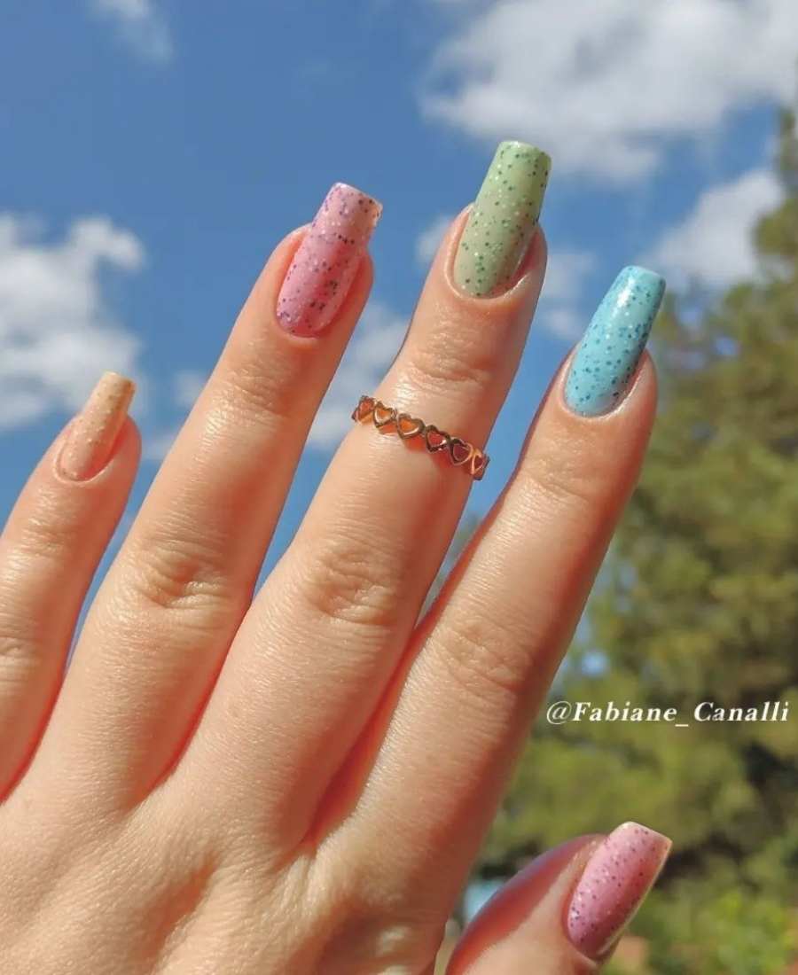mão de mulher de cada cor: amarelo, rosa, verde, azul e rosa, com glitter por cima.