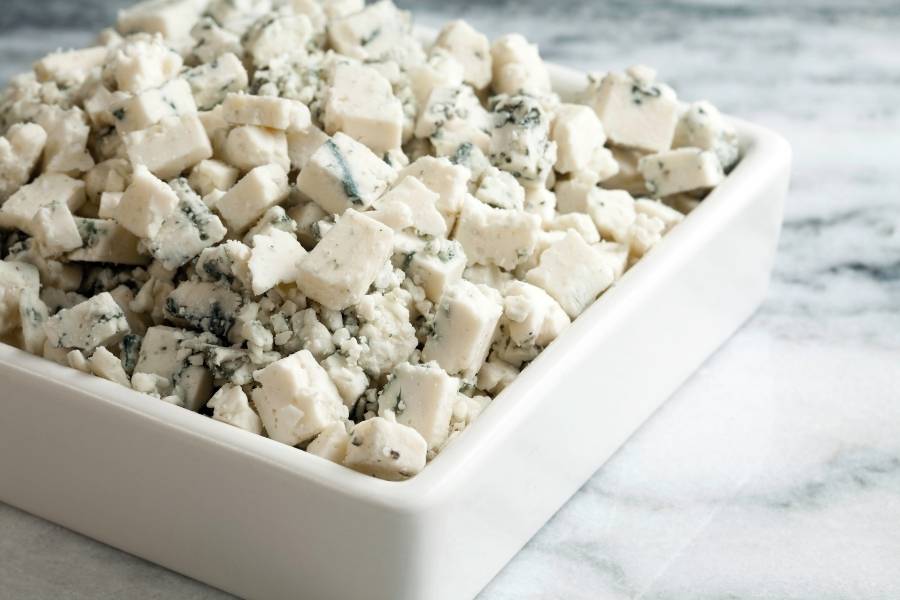 tigela de cerâmica branca com cubos de queijo blue cheese