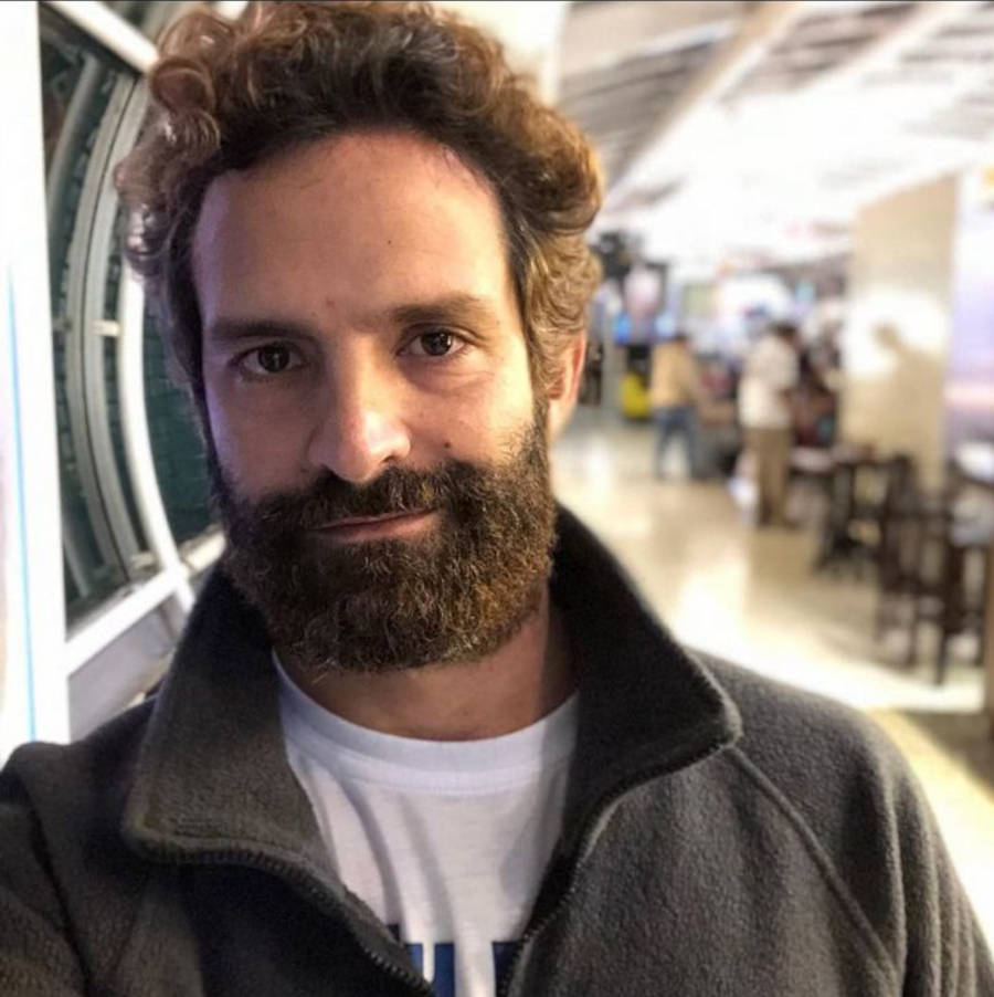 Foto do ator Iran Malfitano com cabelo e barba grande