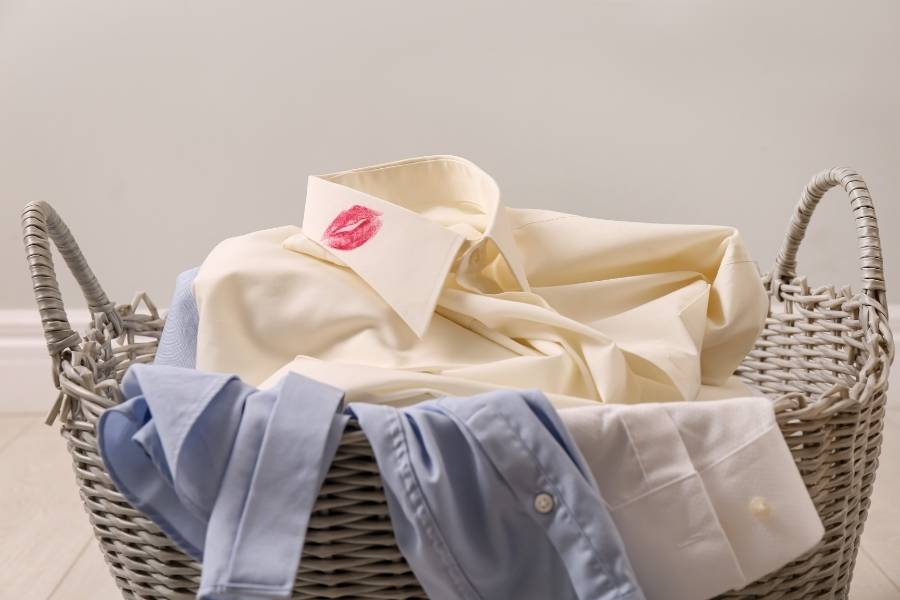 cesta de roupas para lavar com camisa suja de batom no colarinho