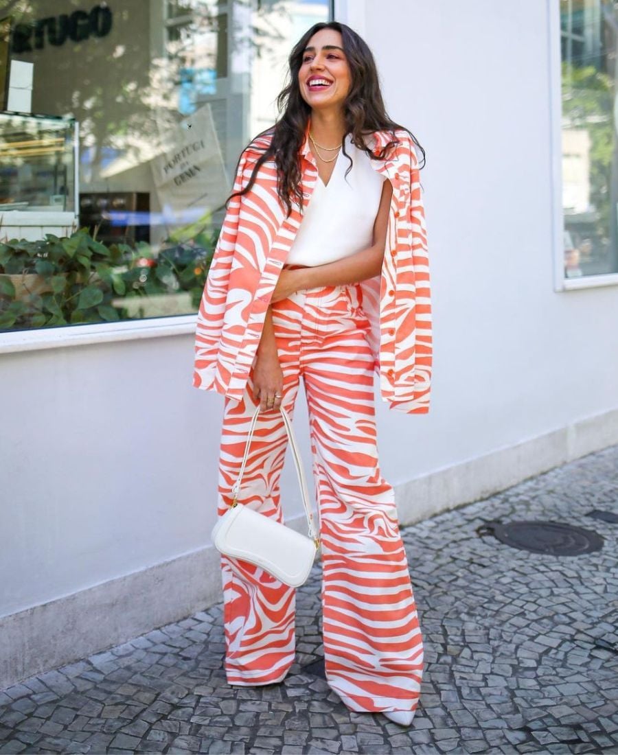 mulher usando blusa branca e conjunto de zebra laranja