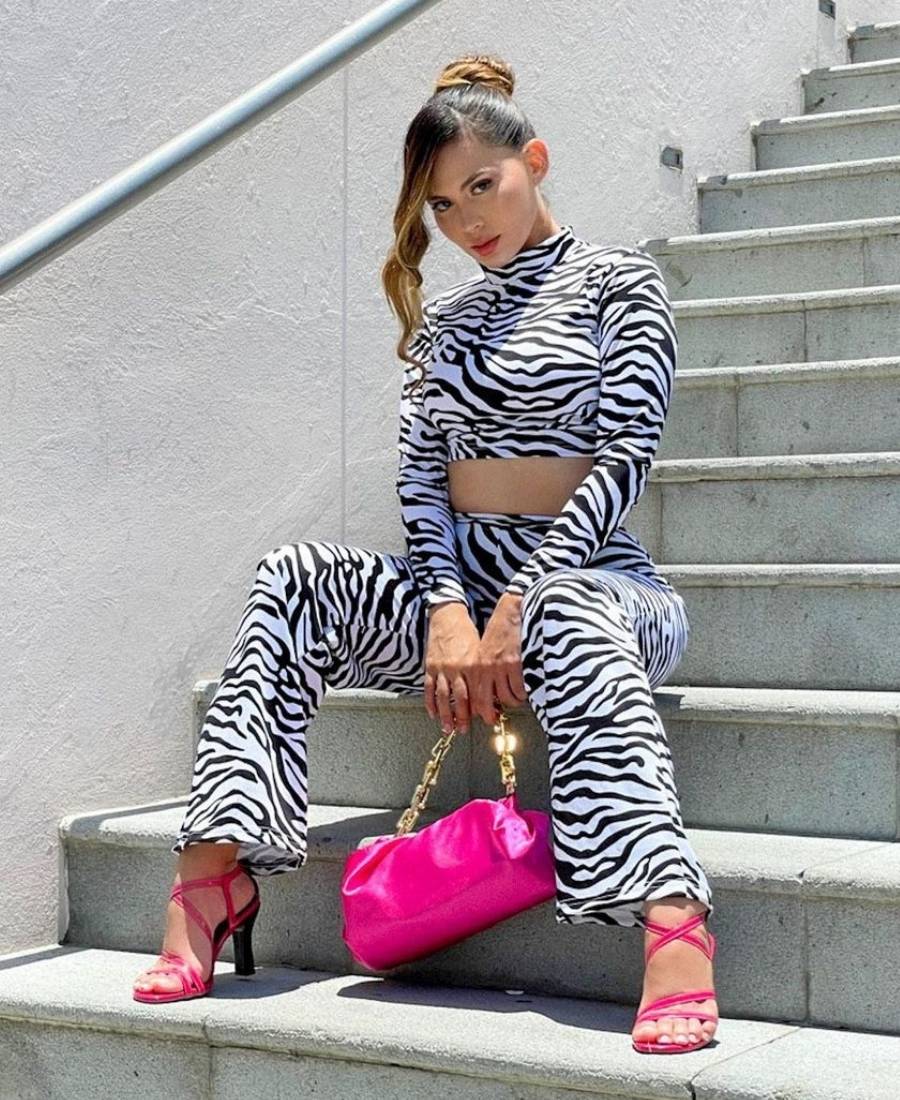 mulher usando cropped, calça, sandália e bolsa pink